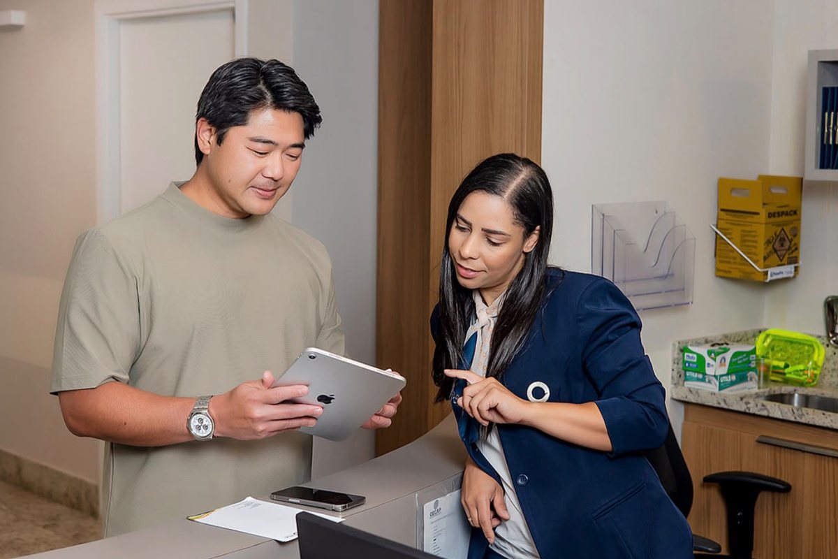 Dr. Rafael Kenji e uma integrante da equipe conferindo informações em um tablet